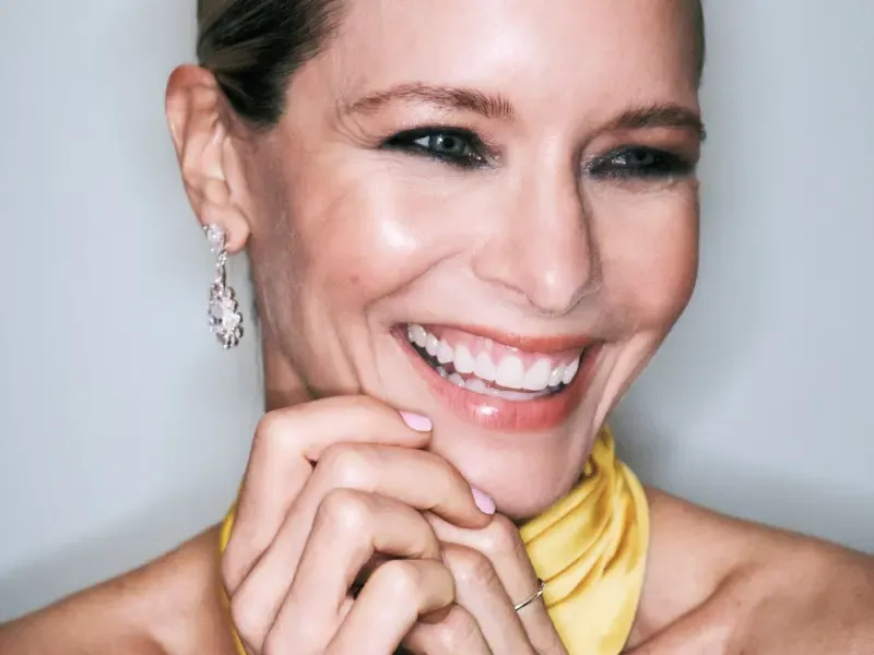 At-home beauty services close-up of smiling woman with natural makeup, glowing skin, and elegant earrings