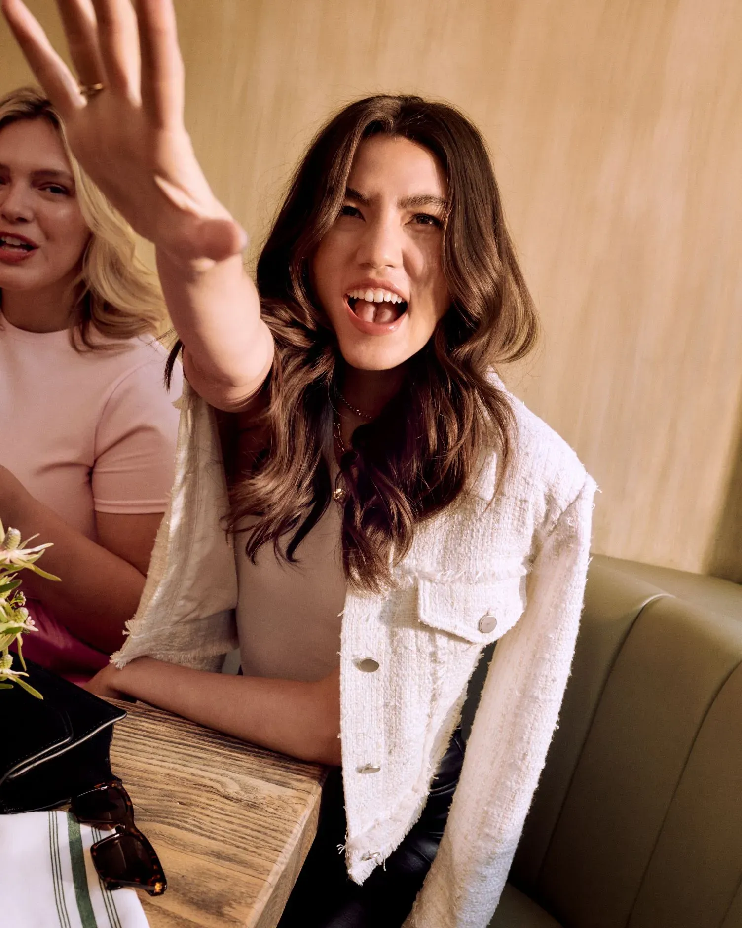 Blowout hair products keep hair smooth and manageable, as shown by a woman with flawless, styled waves at brunch.