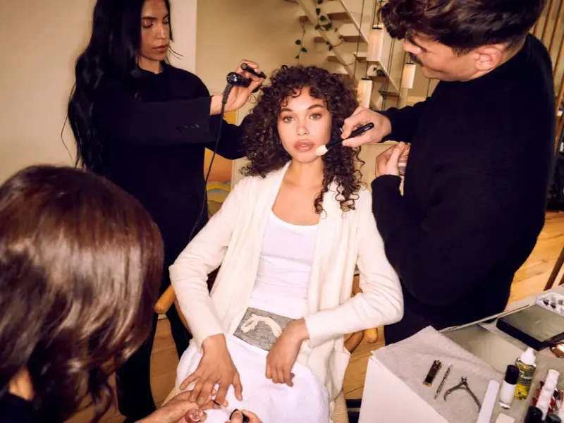 Bridal beauty prep with a woman receiving professional hair, makeup, and nail services before her wedding.